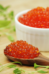 A small ceramic bowl with red caviar