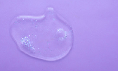 Cosmetic transparent gel smudge smear lavender purple background