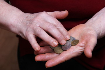 The pensioner's hands count coins. Russian roubles.