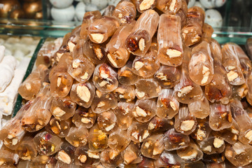 Cevizli sucuk made by dipping a string with walnuts into a grape molasses mixture