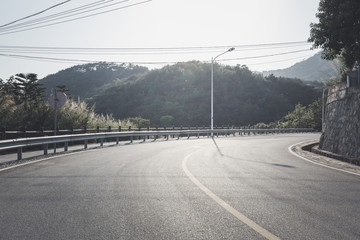Curved mountain road with sunlight