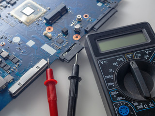 Multimeter test, electronic board of digital device with components. Troubleshoot electronic device. Computer and mobile device repair concept.