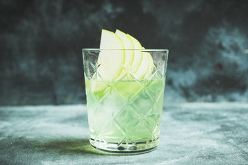 Green apple beverage on the rustic background. Selective focus.
