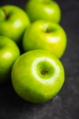 Close-up green apples on the rustic wooden background. Selective focus. Shallow depth of field.
