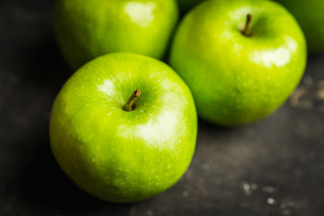 Close-up green apples on the rustic wooden background. Selective focus. Shallow depth of field.
