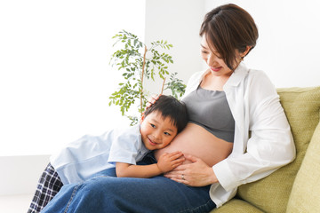 赤ちゃんの鼓動を聞く小さな男の子
