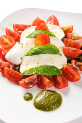 caprese from the Campania area mozzarella, tomatoes and pesto of basil,  called caprese on white background