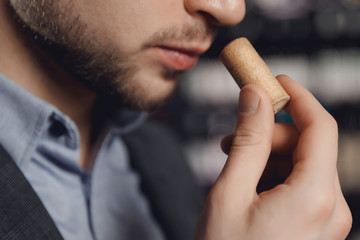 Professional sommelier waiter examining smell of wine cork