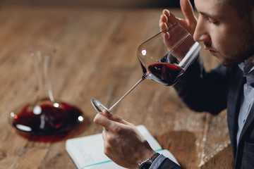 Winemaker sommelier man sniffing aroma red wine in glass