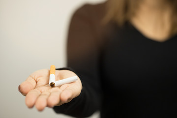 Close-up of a person holding a cigarette in their hand.