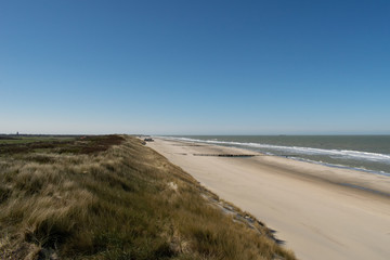 Fototapeta na wymiar Sand dunes near to the sea with blue sky