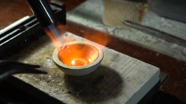 Silver casting for jewellery production. The temperature of gold is too high to melt. The blowtorch heats the ore for melting