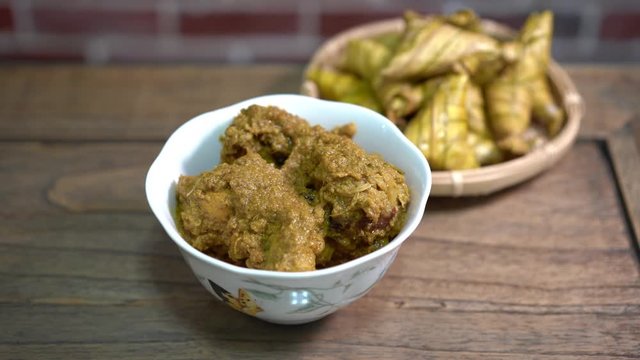 Cinematic shot of ketupat palas and chicken rendang, traditional malay cuisines typically served during eid