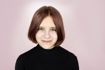 Portrait of a cute beautiful teenage girl on a pink background, the girl has painted hair and a new hairstyle. Girl smiling