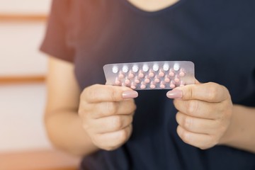 Women holding birth control pills in their hands