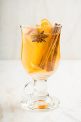 Healthy hot beverage with oranges, apples and spices for protection in flu season. Selective focus. Shallow depth of field.