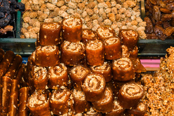 Cevizli sucuk made by dipping a string with walnuts into a grape molasses mixture