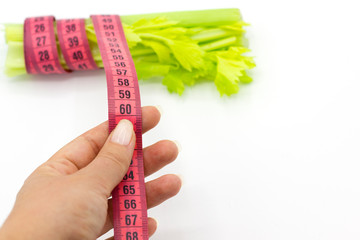 women hand showing her goal with centimeter. perfect waist 60 cm. Concept of weight loss, celery...