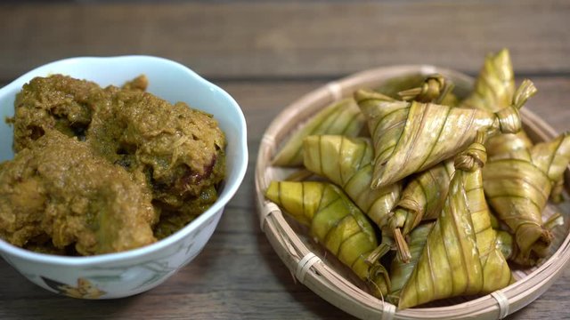 Cinematic shot of ketupat palas and chicken rendang, traditional malay cuisines typically served during eid