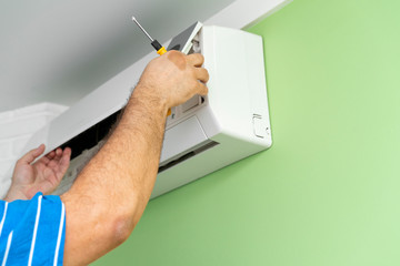 Male technician repairing and diagnosing air conditioners. Husband for an hour