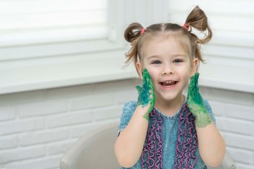 Little girl paints with fingers