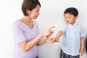 子どもにスプレーをするお母さん