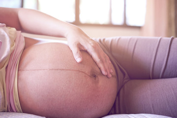 healthcare and medical care concept close up male doctor hand checking up on pregnant woman, using stethoscope checking fetus baby infant inside, pregnancy checkup into parenthood motherhood lifestyle