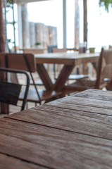 Obraz premium A used wooden table in the foreground, sharply focused. In the background there are more tables and chairs from the beach bar in the Netherlands. A cozy, picturesque location.