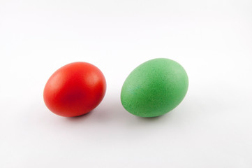 Two easter eggs, red and green, isolated on white background, colored by easter bunny