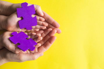 Adult and chiild hands holding jigsaw puzzle,Autism awareness,Autism spectrum disorder family support concept, World Autism Awareness Day.