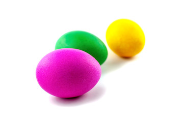 Three easter eggs, red and green, orange or yellow, isolated on white background, colored by easter bunny