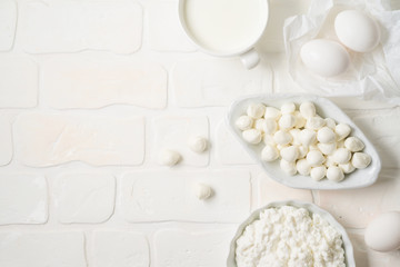 Fototapeta na wymiar Dairy products on white background. Mozzarella, milk, eggs and cottage cheese. Top view from above