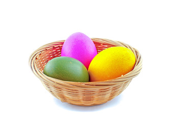 A basket bowl full of Easter eggs. The Easter bunny hid the eggs, the children looked for and found the eggs in the morning. There will be Easter breakfast soon.