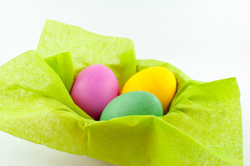 A ceramic bowl full of Easter eggs. The Easter bunny hid the eggs, the children looked for and found the eggs in the morning. There will be Easter breakfast soon.