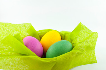 A ceramic bowl full of Easter eggs. The Easter bunny hid the eggs, the children looked for and found the eggs in the morning. There will be Easter breakfast soon.