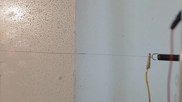 Close up: Cutting plastic foam. Automatic cutting of expanded polystyrene (foam plastic). Cutting out volumetric letters of foam plastic. Figured cutting of foam plastic.