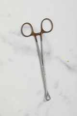 surgical metal plier on marble back medical tool