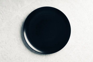 Clean black plate on the rustic background. Selective focus. Shot from above.