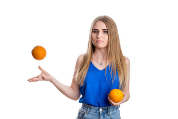 A girl in bright blue jeans and a blouse with oranges in her hand