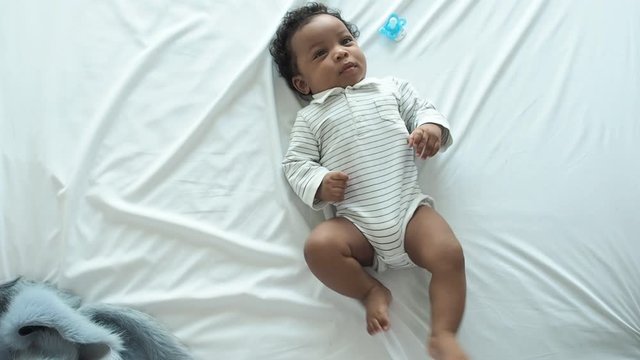 African newborn baby boy lying in bed and wriggle in the morning.Happy,excited,smile and enjoy emotion.He have beautiful eyes.