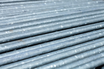 shiny metal pipes stacked in rows