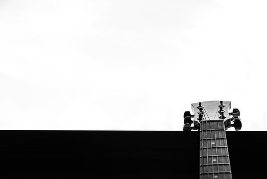 Guitar In A Window, Overexposed White Background. Selective Focus. B&W. Copy Space.