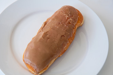 Maple bar on white plate closeup of this favorite baked good donut snack.