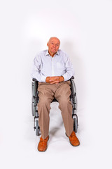 elderly man sits smiling in his wheelchair
