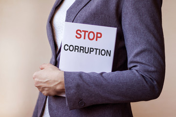Business woman holds a banner with the inscription Stop corruption