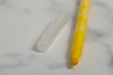 white marble background yellow marker isoleted. Kid pen