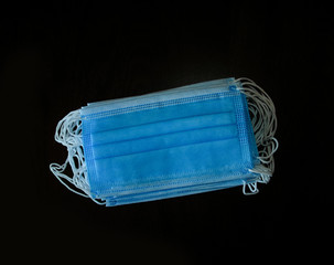 a pack of blue medical masks on a dark background