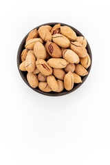 Pecan nuts in shells in round bowl on white background, top view