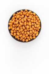 Peanuts in coconut glaze in round bowl on white background, top view