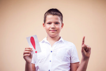 A portrait of kid boy holding cards with exclamation point. Childhood and education concept